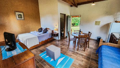 a bedroom with a bed and a table and chairs at Pousada Sitio da Terra e Arte in São Roque