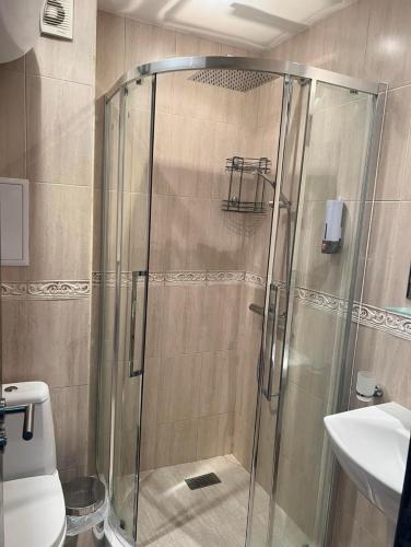 a shower with a glass door in a bathroom at Менада Хоризонт Апартаменти in Sozopol