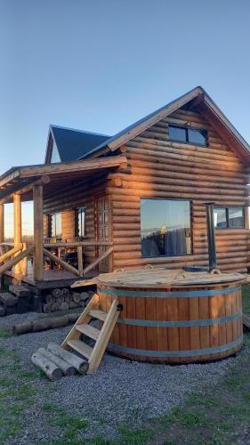 eine Blockhütte mit einem Whirlpool davor in der Unterkunft Estadia de campo in San Andrés de Giles