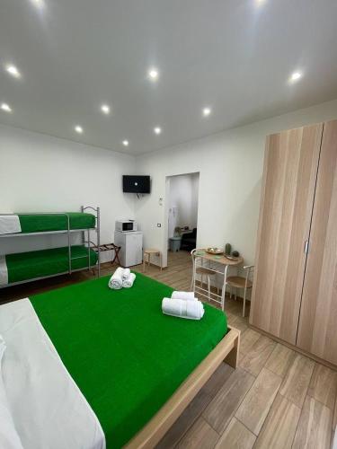 a bedroom with a green bed with two towels on it at Profumi di Sicilia in Cinisi