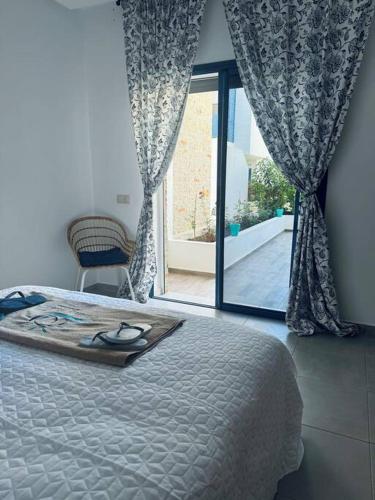 a bedroom with a bed and a large window at Martil Costa-Mar in Martil