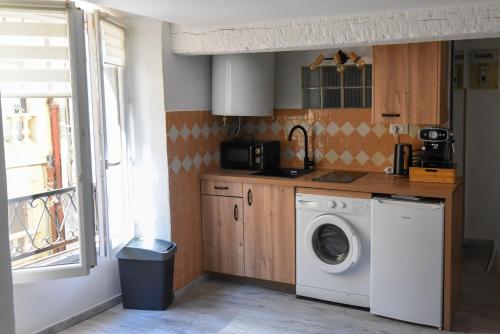 a kitchen with a washing machine and a window at Les Chambres du Clavero in Claviers