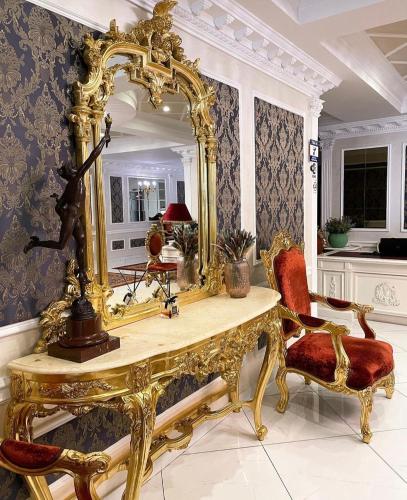a gold dressing table with a mirror and a chair at Royal Olympic Hotel in Kyiv