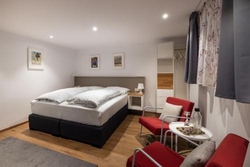 Un dormitorio con una cama y una mesa y sillas. en Gstill-4-Living, en Innsbruck