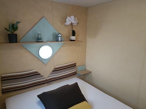Un dormitorio con una cama blanca y un estante. en chezfantine, en Dannes