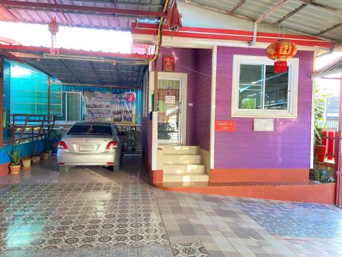 a car parked in front of a purple house at บุญจินดา รีสอร์ท in Ban Phayom