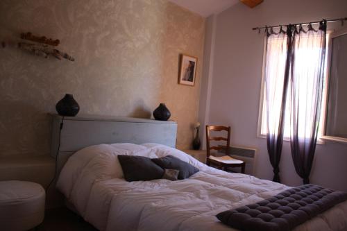 a large bed in a bedroom with a window at La Remiso in Montfaucon