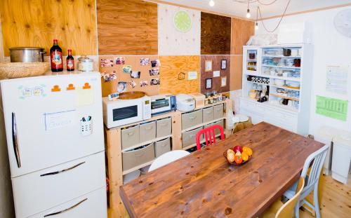 a kitchen with a wooden table and a refrigerator at 女性専用まちやど -Women Only- in Gujo