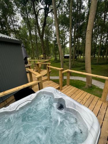 a hot tub sitting on a wooden deck at Riverside Cabins in Shrewsbury