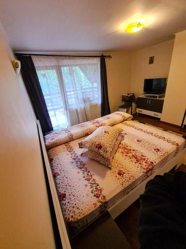 a bedroom with a bed with flowers on it at Vis de Munte in Mănăstirea Humorului