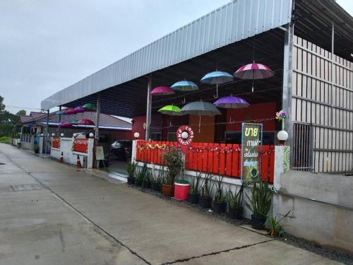 a building with colorful umbrellas hanging from it at บุญจินดา รีสอร์ท in Ban Phayom