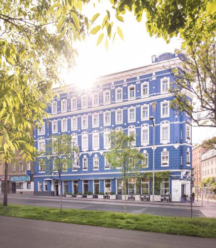un gran edificio azul en una calle de la ciudad en BoutiqueHOTEL Donauwalzer, en Viena