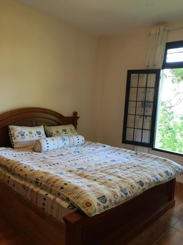 a bed with pillows on it in a bedroom at Smiling Pine Dalat in Ấp Man Ling
