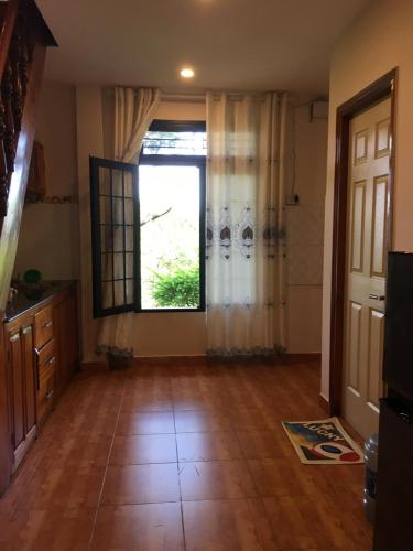 a living room with a large window and a wooden floor at Smiling Pine Dalat in Ấp Man Ling