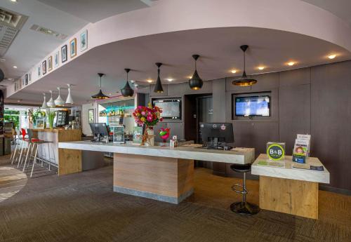 a restaurant with a counter and a bar in a room at B&B HOTEL Chartres Centre Cathédrale 3 étoiles in Chartres