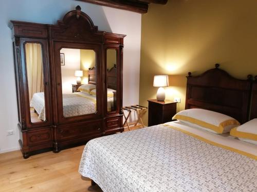 a bedroom with two beds and a large mirror at Agriturismo Il Leone della Torre in Contrada Ronchiel
