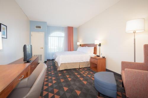 a hotel room with a bed and a tv at Holiday Inn & Suites Goodyear - West Phoenix Area by IHG in Goodyear