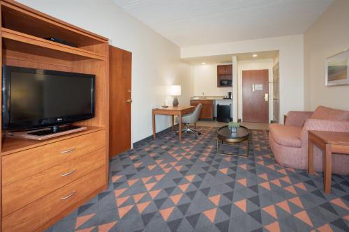 a living room with a flat screen tv and a couch at Holiday Inn & Suites Goodyear - West Phoenix Area by IHG in Goodyear