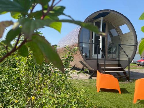 a round house with orange chairs in front of it at Eco-lodge nabij Giethoorn in Wanneperveen