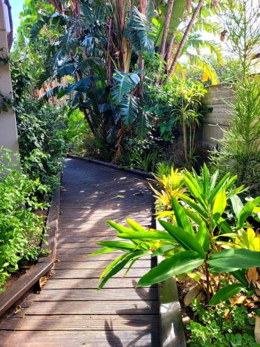 a wooden walkway in a garden with plants at Suite 9- Deja' Blu Bed and Breakfast- East London in East London