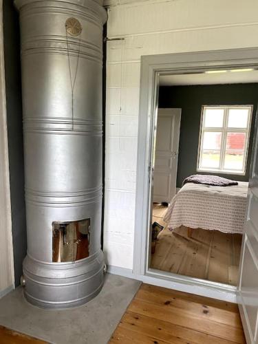 a room with a fireplace with a bed in it at Älvstugan in Övertorneå
