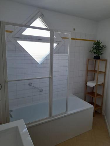 une salle de bain avec une baignoire et une fenêtre dans l'établissement Appartement Avignon Décoration contemporaine, à Avignon