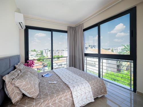 a bedroom with a bed and large windows at Starlight Terrace PENTHOUSE in Marmara