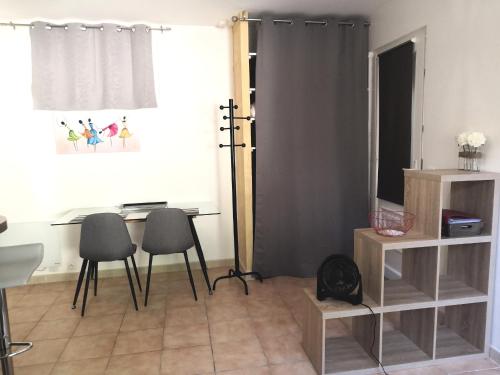 Cette chambre comprend une table, des chaises et un miroir. dans l'établissement Studio avec piscine privée à 5 minutes de la mer, à Saint-Paul-de-Vence