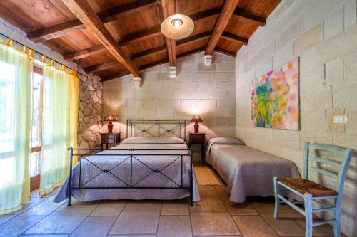 a bedroom with two beds and a wooden ceiling at Masseria Copertini in Vernole