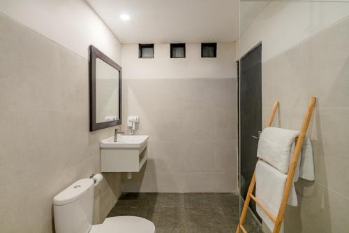 a bathroom with a toilet and a sink and a mirror at Villa Kisaraa - Kerobokan x Seminyak x Canggu in Kerobokan