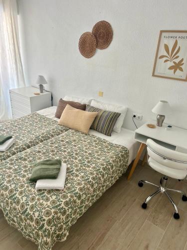 a bedroom with a bed and a desk and a bed and a chair at Harmonia in Punta Prima