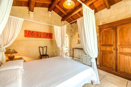 a bedroom with a white bed and a wooden ceiling at Masseria Copertini in Vernole