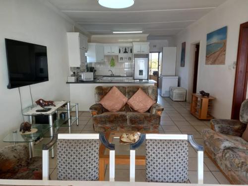 una sala de estar con un sofá y una mesa en Holiday unit 54 Eden Dunes, en Shelly Beach
