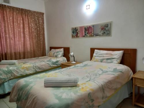 a bedroom with two beds and a window at Holiday unit 54 Eden Dunes in Shelly Beach