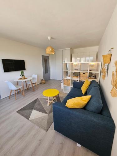 un salon avec un canapé bleu et une table dans l'établissement Studio La Belle Vue, à Metz