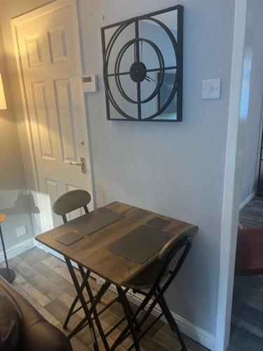 a wooden table and a chair in front of a door at Loch Lomond Riverside Apartments A in Balloch