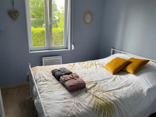 - un lit avec deux sacs dans une chambre dans l'établissement La maison du Marais, à Tilques