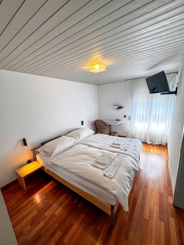 a bedroom with a large white bed in a room at Dogan's Langenthal in Langenthal