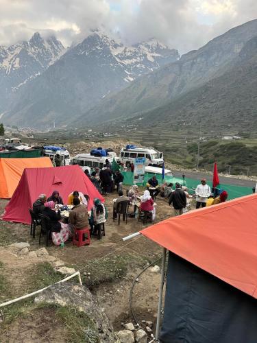 a group of people sitting at tables in front of tents at Buddy Hikers Stay Badrinath in Badrīnāth