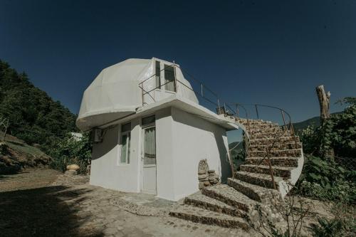 a white building with stairs leading up to it at Amaghlebakari in Batumi