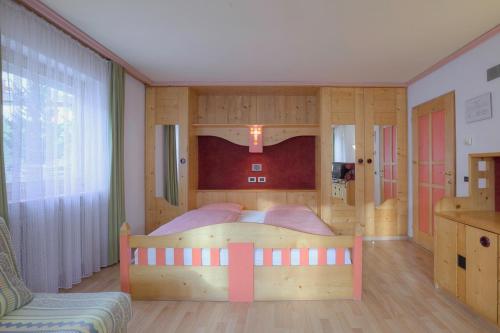 1 dormitorio con 1 cama grande de madera en una habitación en Ciasa La Ro, en San Cassiano