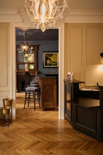 a living room with a chandelier and a table and chairs at Hôtel du Château Bois Guibert in Bonneval