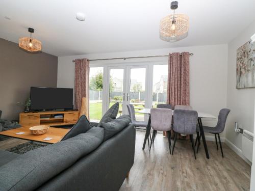 a living room with a couch and a table at 7 Parc Delfryn in Brynteg