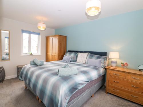 a bedroom with a large bed and a wooden dresser at 7 Parc Delfryn in Brynteg
