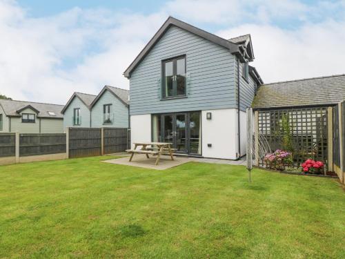 a house with a picnic table in a yard at 7 Parc Delfryn in Brynteg