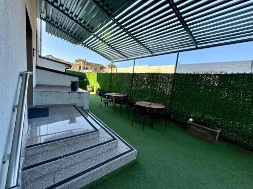 an outdoor patio with tables and chairs and a fence at Vila Eric in Eforie Sud