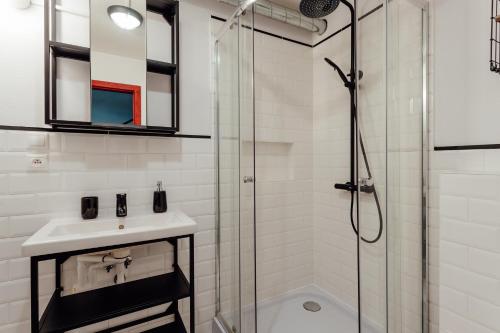 a white bathroom with a sink and a shower at Fajnové apartmány in Vyhne