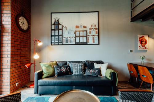 a living room with a blue couch and a clock at Fajnové apartmány in Vyhne