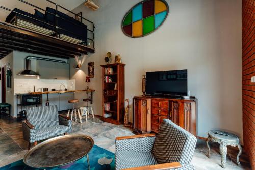 a living room with a tv and a table and chairs at Fajnové apartmány in Vyhne
