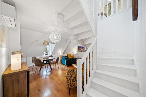 - un escalier blanc dans un salon avec une table dans l'établissement La Terrasse de La Tour, à Beaune